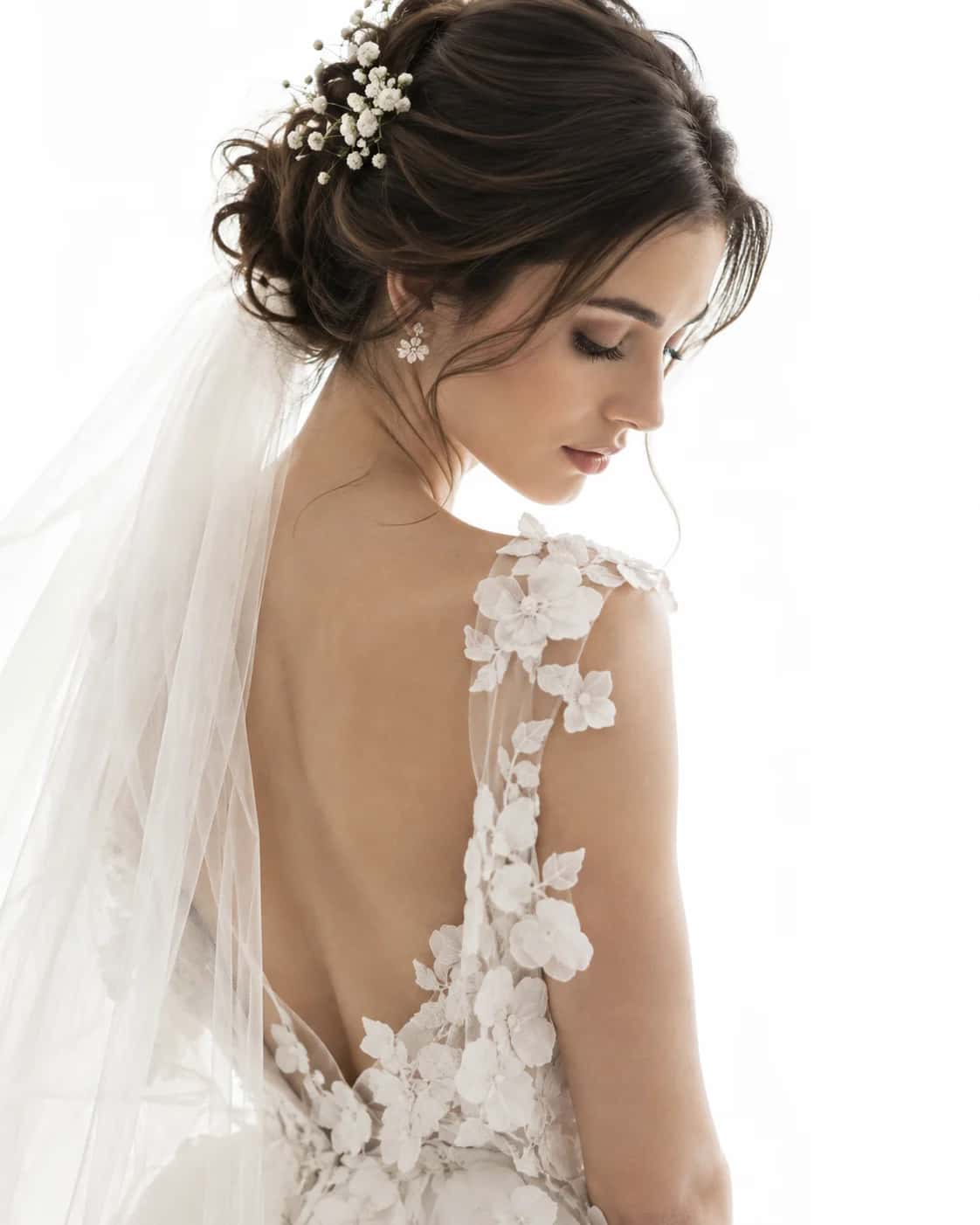 A quiet bridal portrait in white floral couture and a flowing ivory veil